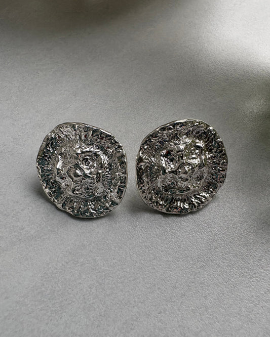 Two silver organic earrings  on a gray background