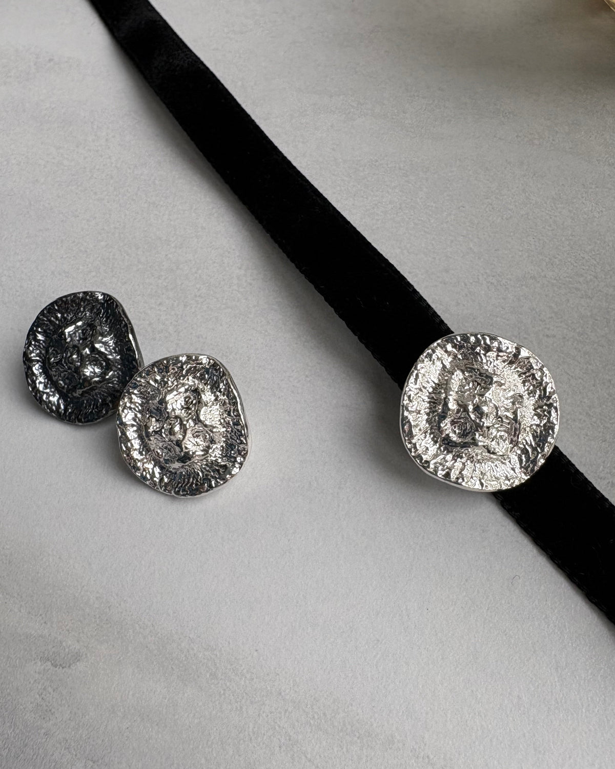 three silver hoker pendants with a black velvet ribbon