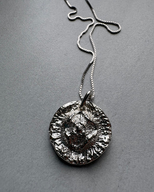 Organic Silver pendant necklace on a gray background
