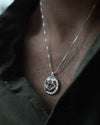 Silver necklace with a pendant worn by a person