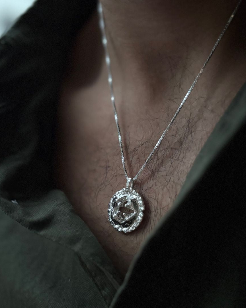 Silver necklace with a pendant worn by a person