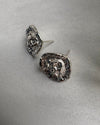 Pair of silver textured earrings on a light gray background