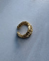 Gold organic ear cuff earring on a gray background