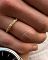 Hand wearing a gold ring and silver watch 