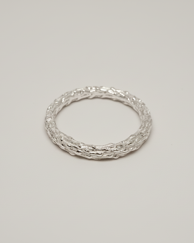 packshot of an organic ring on a light beige seamless background