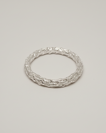 packshot of an organic ring on a light beige seamless background