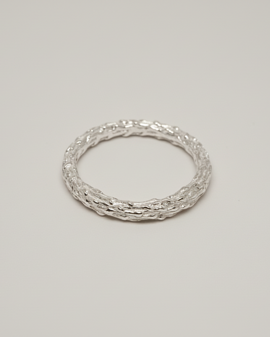 packshot of an organic ring on a light beige seamless background