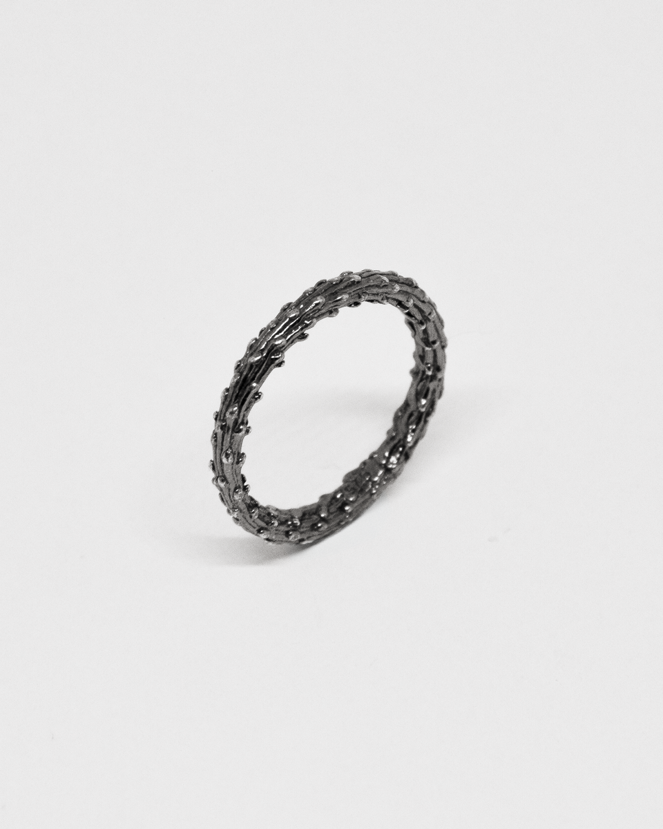 oxidised silver organic ring on a light gray background