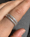 Silver ring on a finger against a neutral background
