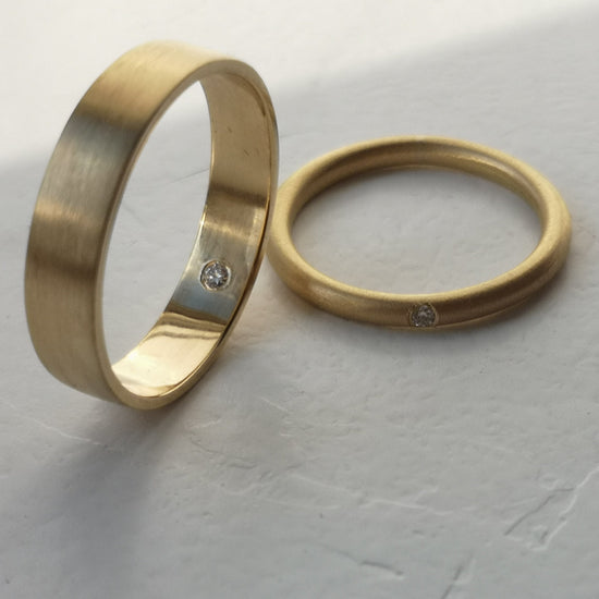 Two gold rings on a textured gray surface