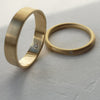 Two gold rings on a textured gray surface