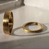 Two gold rings on a textured white surface