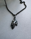 O xidised Silver necklace with a leaf pendant on a gray background