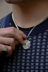 model with a textured blue and grey sweather wearing an organic botanical silver necklace and ring