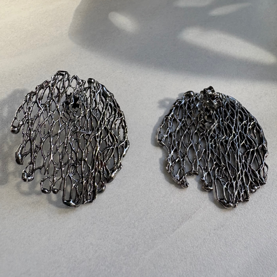 Pair of oxidised silver earrings on a light surface
