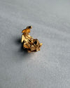 gold leaf ear cuff on a grey surface