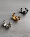 Three silver leaf shaped ear cuff  earrings on a gray surface