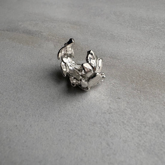 Silver leaf earcuff on a gray textured background