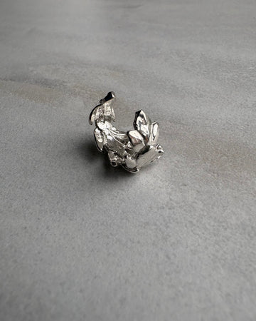 Silver leaf earcuff on a gray textured background