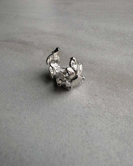 Silver leaf earcuff on a gray textured background