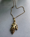Goldplated  necklace with leaf pendant on a gray background