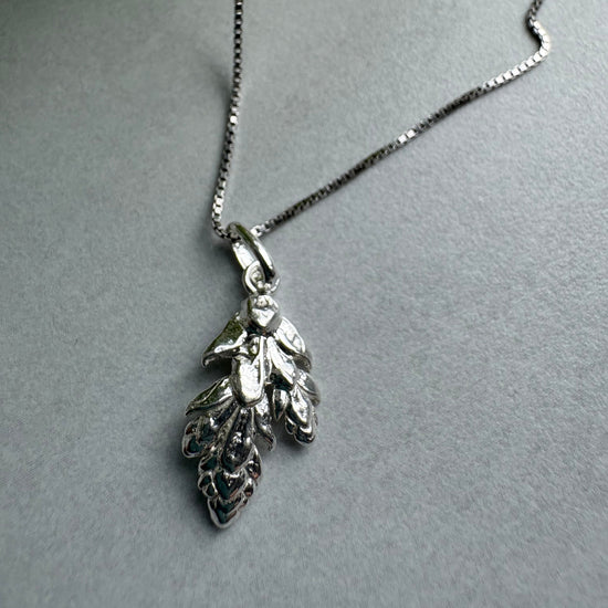 Silver leaf pendant necklace on a gray background