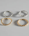 4 silver rings on light grey background with organic texture