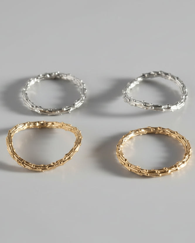 4 silver rings on light grey background with organic texture