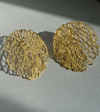 Pair of gold lace-style earrings on a light gray background